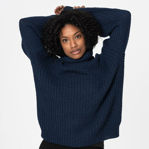Woman wearing a navy knitted turtleneck sweater. Ethically made sweaters by Dinadi for Mulxiply.