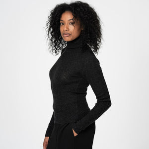Woman wearing a black turtleneck sweater against a white background