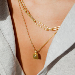 The necklace features a delicate chain with small sterling pearl