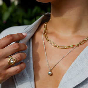 The necklace is designed to be worn at a medium length, resting gracefully on the collarbone.