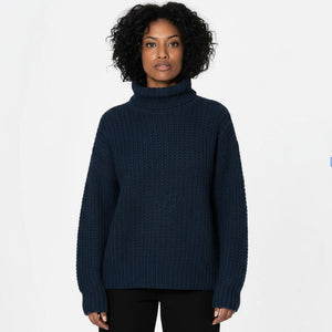 Woman wearing a dark blue turtleneck sweater on a white background
