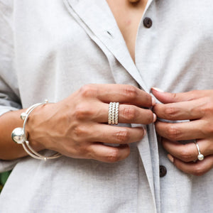  The ring is made of shiny sterling silver and features an intricate twisted rope design. 