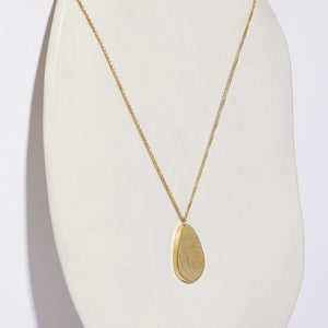 Pod-shaped necklaced in brass by Mulxiply.