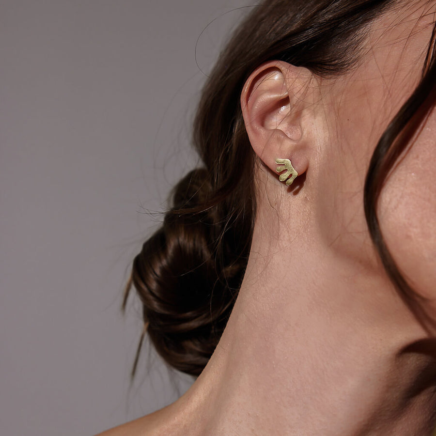 Mod shaped brass stud earrings.