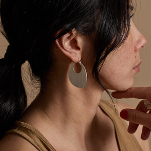 Modern, hammered silver hoop earrings.
