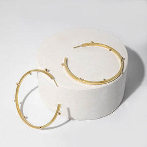 Delicate brass hoop earrings, designed in Maine, made in Nepal.